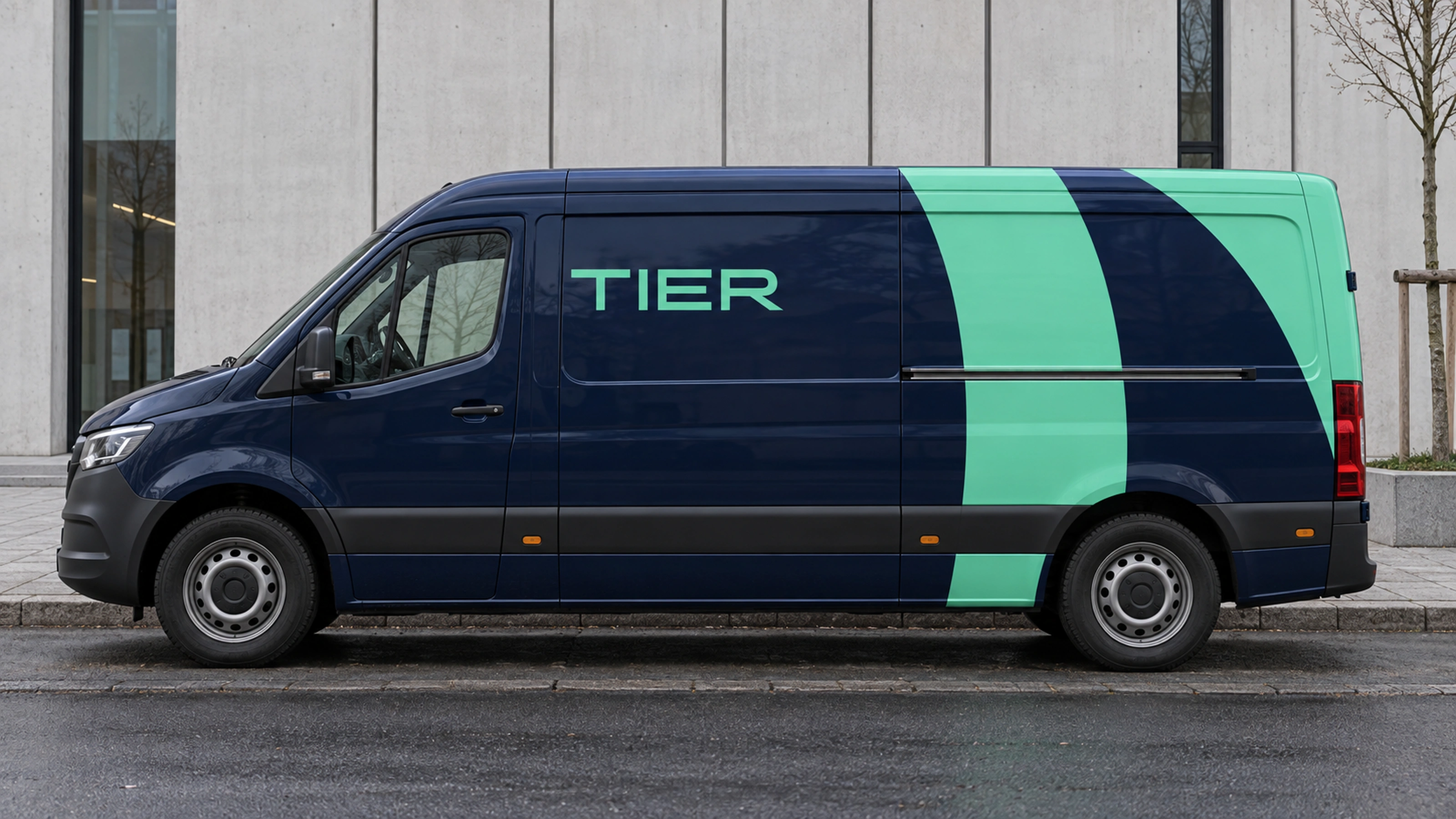A service van in navy with a mint ribbon and the wordmark.