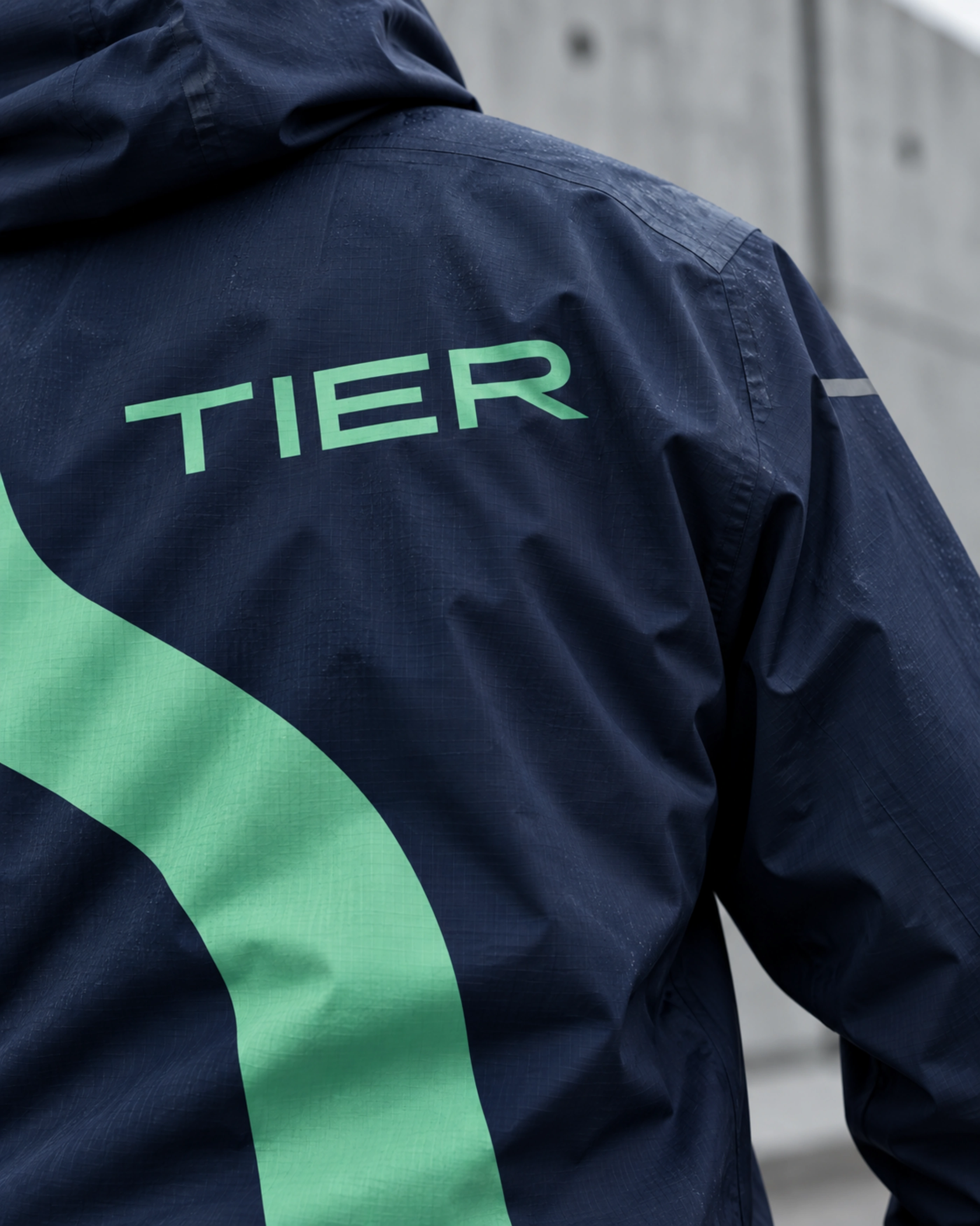 The back of a navy jacket with a mint ribbon and the wordmark.