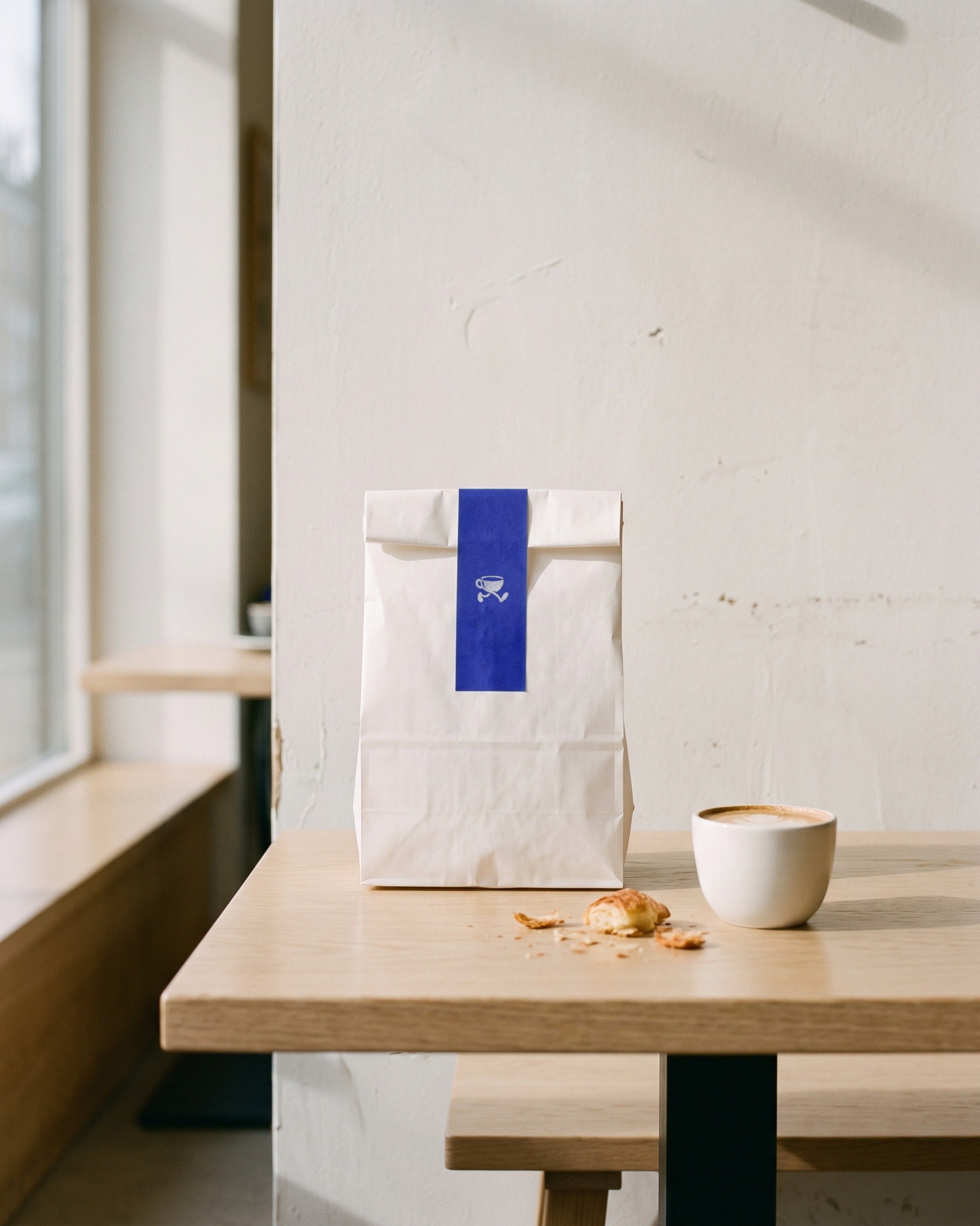 A white takeaway bag closed with the blue band.