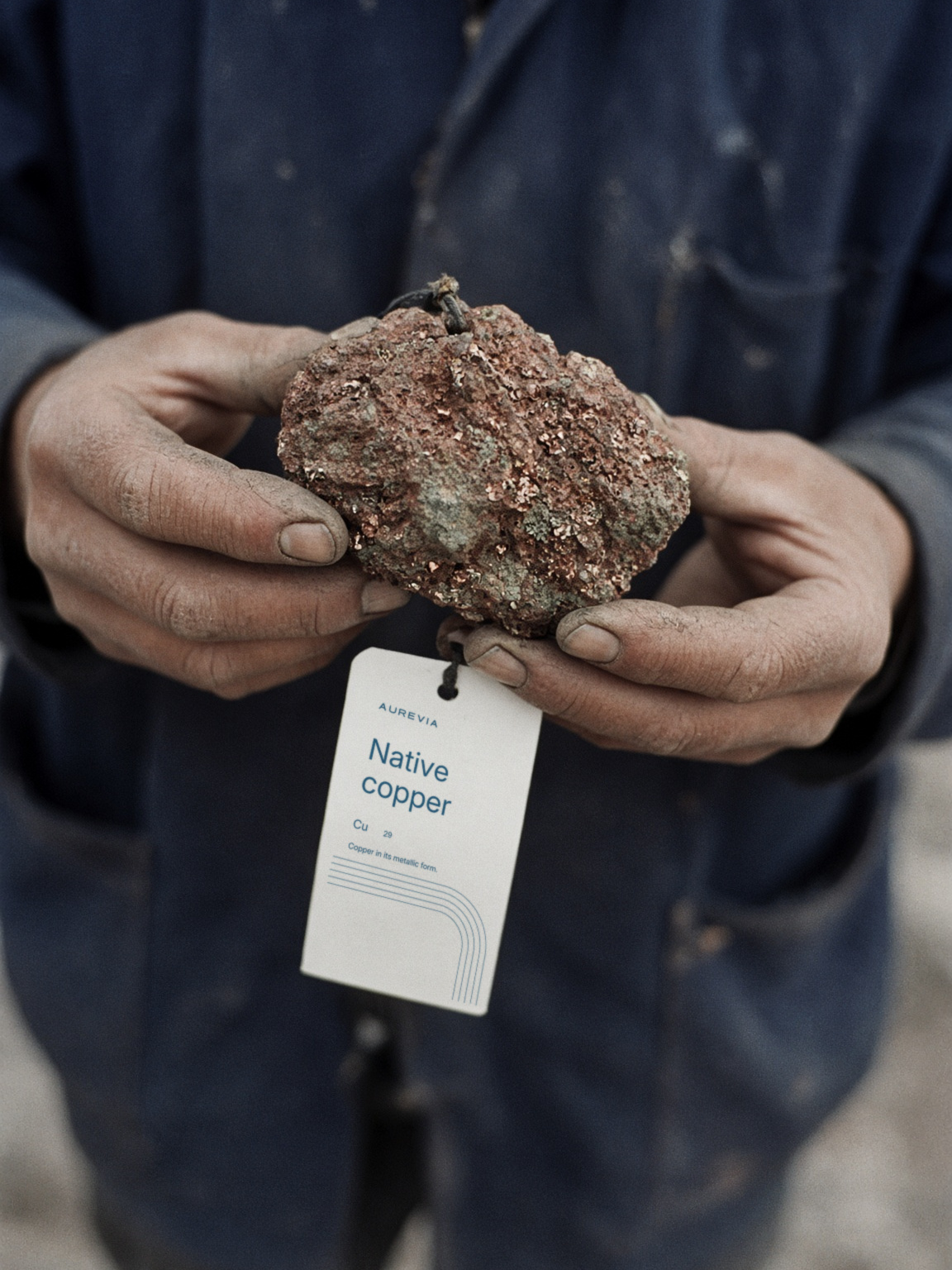 Native copper held up with its paper sample tag: Cu, native copper, copper in its metallic form.