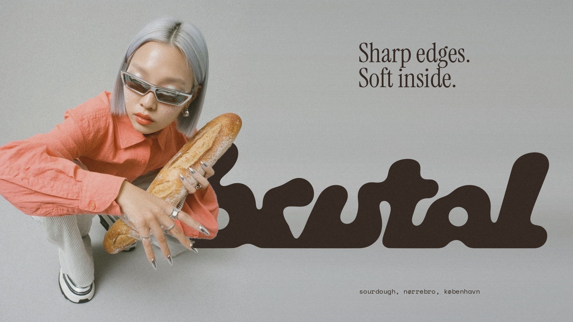 A baker crouching in chrome sunglasses with a baguette in front of the large BRUTAL wordmark: Sharp edges. Soft inside.