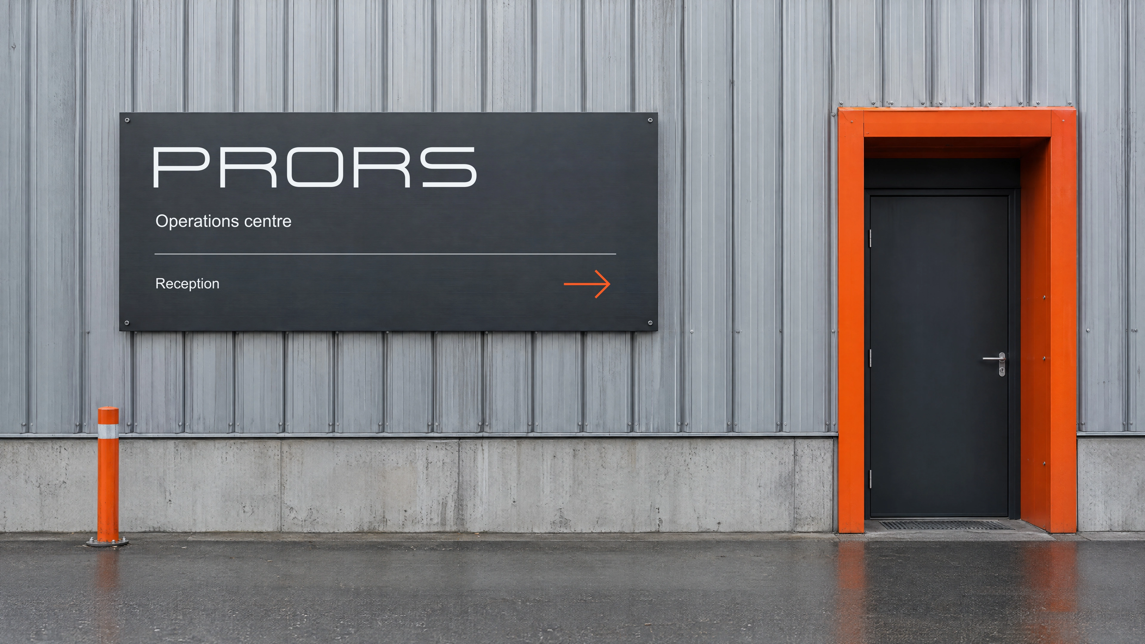 PRORS on a building, the doorway lit in orange.